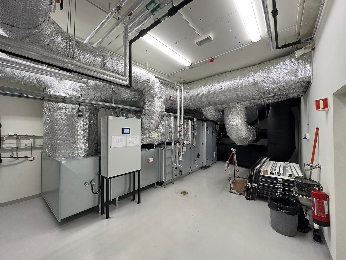 Equipo y conductos de ventilación en una sala técnica de un edificio escolar